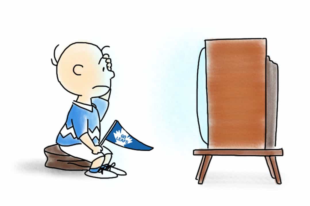 A boy is sitting in front of a TV, looking distressed and holding a Toronto Maple Leafs flag in his hand.